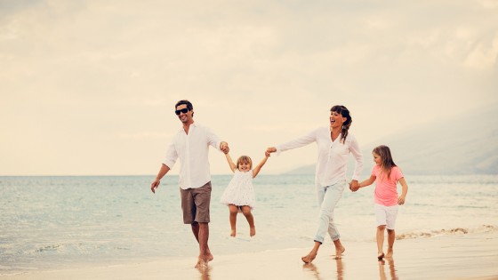 Happy Young Family have Fun Walking on Beach at Sunset