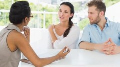 Therapist talking with couple sitting at desk