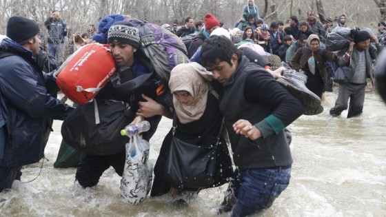 Migrants wade across a river near the Greek-Macedonian border, west of the the village of Idomeni March 14, 2016. REUTERS/Stoyan Nenov